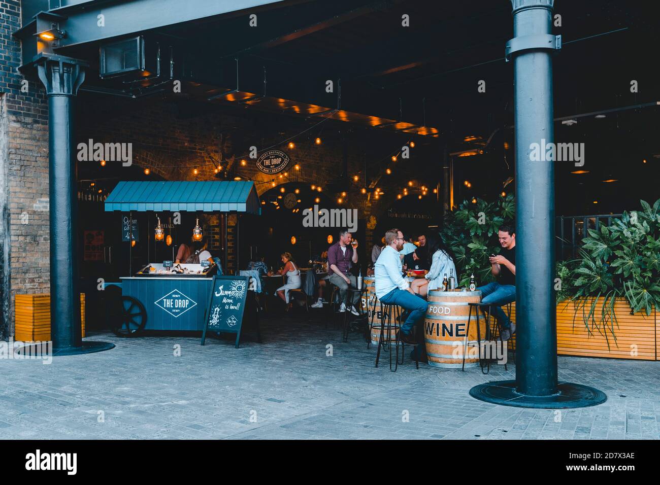 King's Cross London, Großbritannien, 12. Juli 2019: Granary Square, Coal Drops Yard Menschen genießen Geselligkeit, trinken im Freien Nacharbeit, neue Einkaufsviertel in t Stockfoto