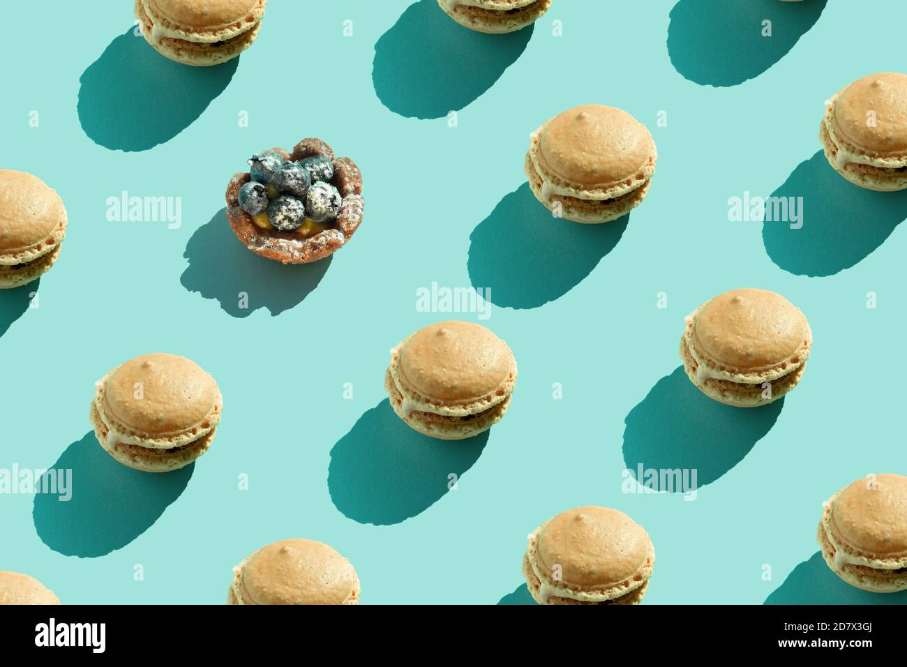 Farbenfrohe französische Plätzchen-Macarons auf pastellblauem Hintergrund. Minimalkonzept. Schokoladendessert, Makronen auf farbiger Oberfläche. Tageslicht, natürlich Stockfoto