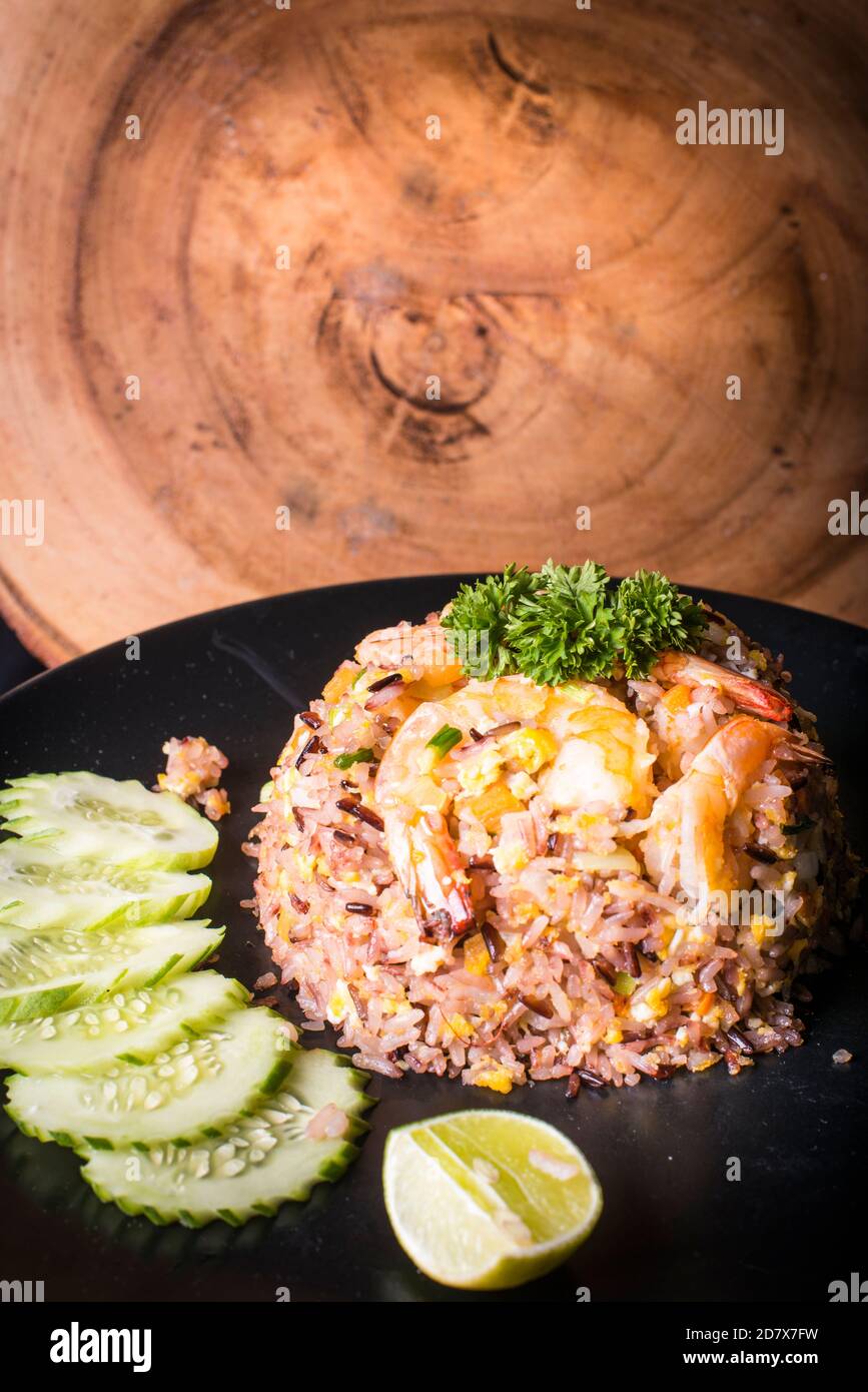 Gebratener Reis mit Garnelen serviert mit Gurke und Limette Stockfoto