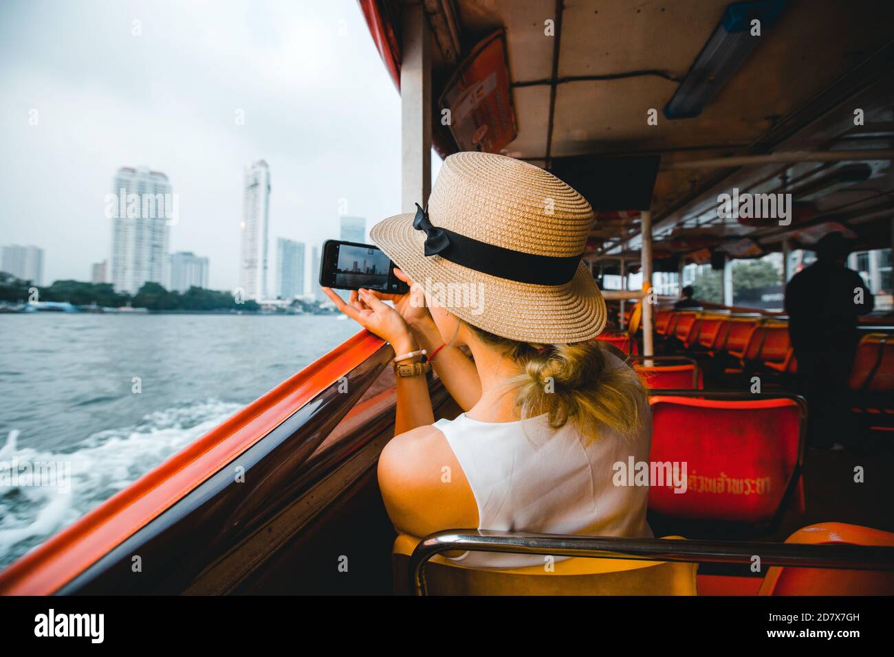 Junge Frau Reisende, die Fotos mit ihrem mobilen Reise zu Thailand mit Hut auf dem Boot in Bangkok Thailand Stockfoto