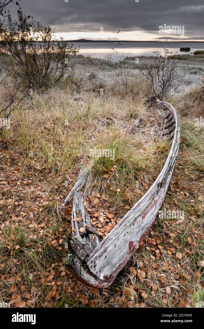 Dramatische Landschaft mit kleinen verlassenen Holzboot an der Seeufer in Finnland. Stockfoto