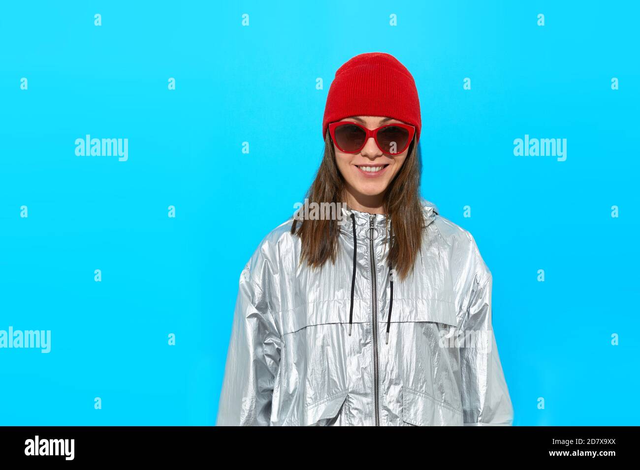 Glückliche Frau in warmer Kleidung und Sonnenbrille Stockfoto