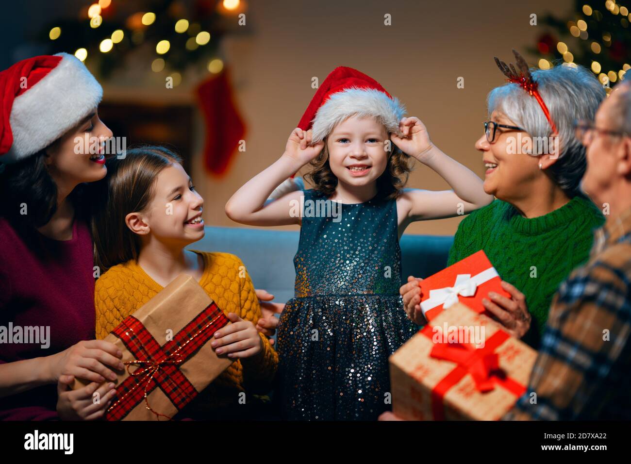 Frohe Weihnachten und schöne Feiertage! Oma, Opa, Mama und Kinder tauschen Geschenke aus. Eltern