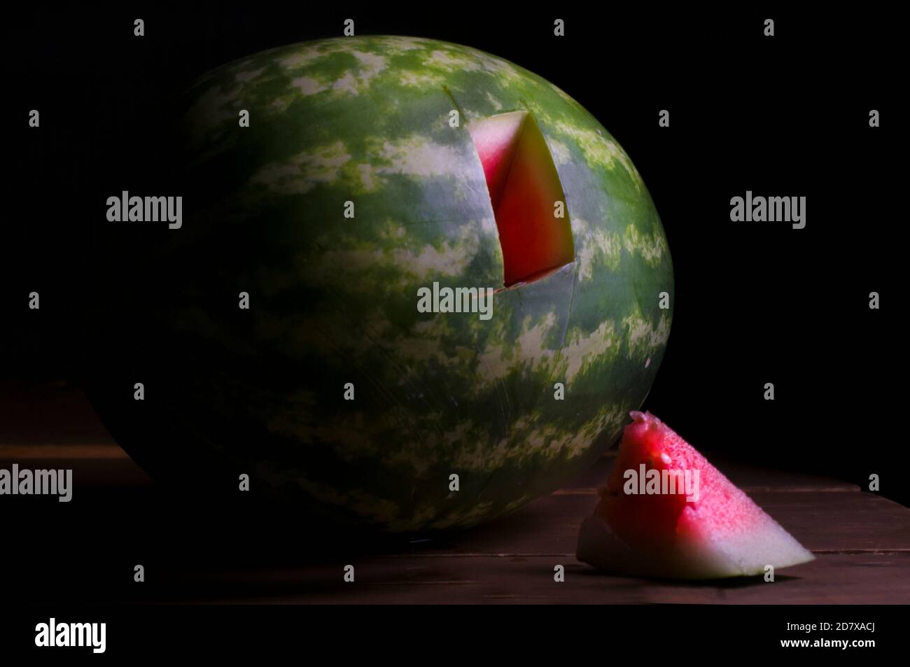Spiking eine Wassermelone, Tests mit einer kleinen Probe von Wassermelone. Chiaroscuro Barockfotografie, Renaissance-Stil, Probe von Wassermelone. Stillleben Stockfoto