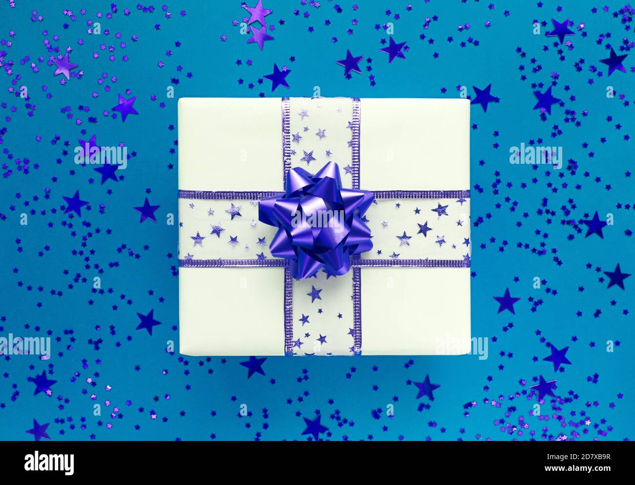 Geschenkbox und Sterne auf blauem Hintergrund. Monochrom flach liegend. Stockfoto