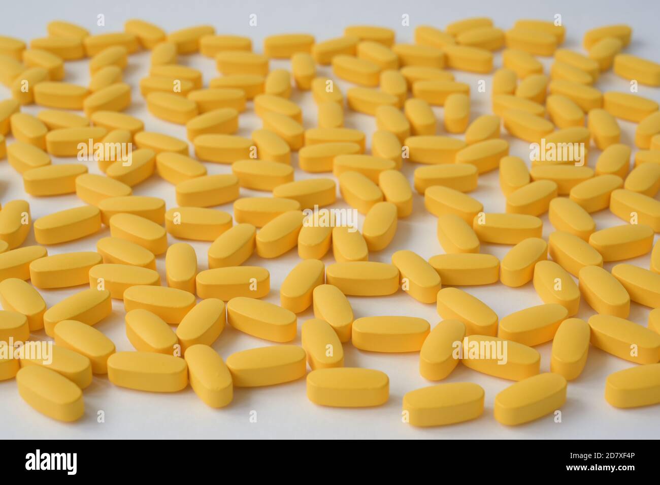 Apotheke Konzept der Handvoll gelber Pillen Tabletten liegen auf Weiße Oberfläche Stockfoto