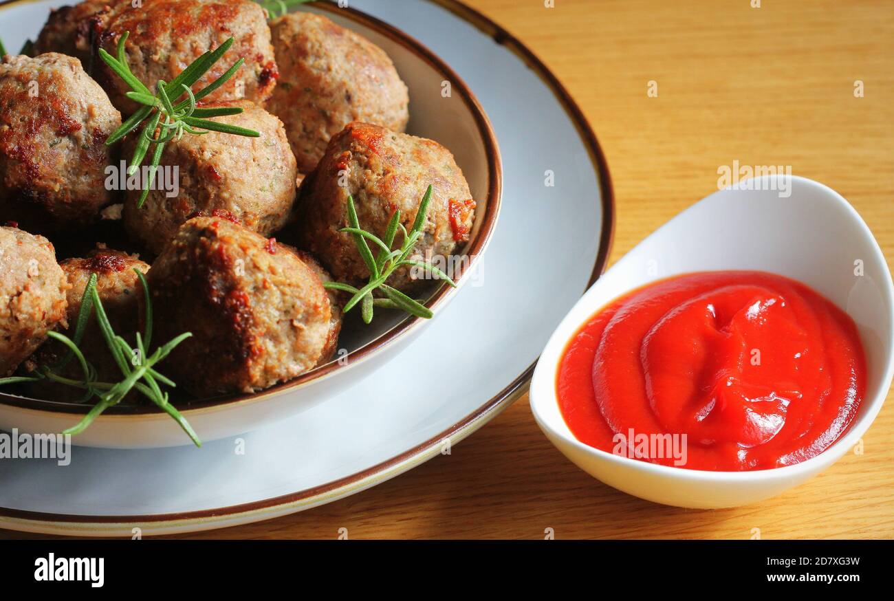 Gebratene Fleischbällchen, leckere Fleischschnitzel mit Tomatensauce auf Holztisch. Stockfoto