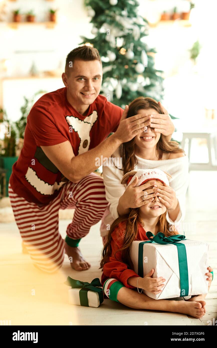 Portrait der glücklichen Familie im Schlafanzug in der Küche Auf dem Weihnachtsbaum Hintergrund Stockfoto