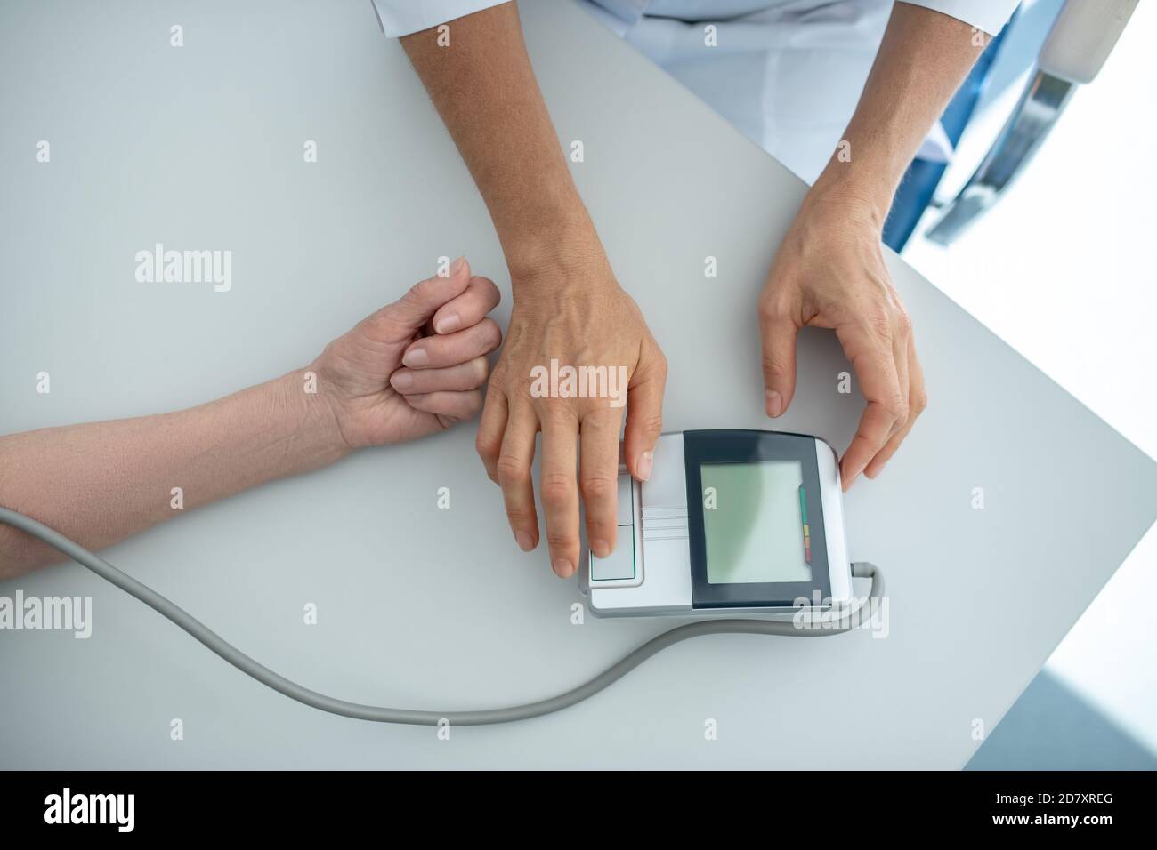 Nahaufnahme der Ärzte Hände Messung Blutdruck zu einem Patienten Stockfoto