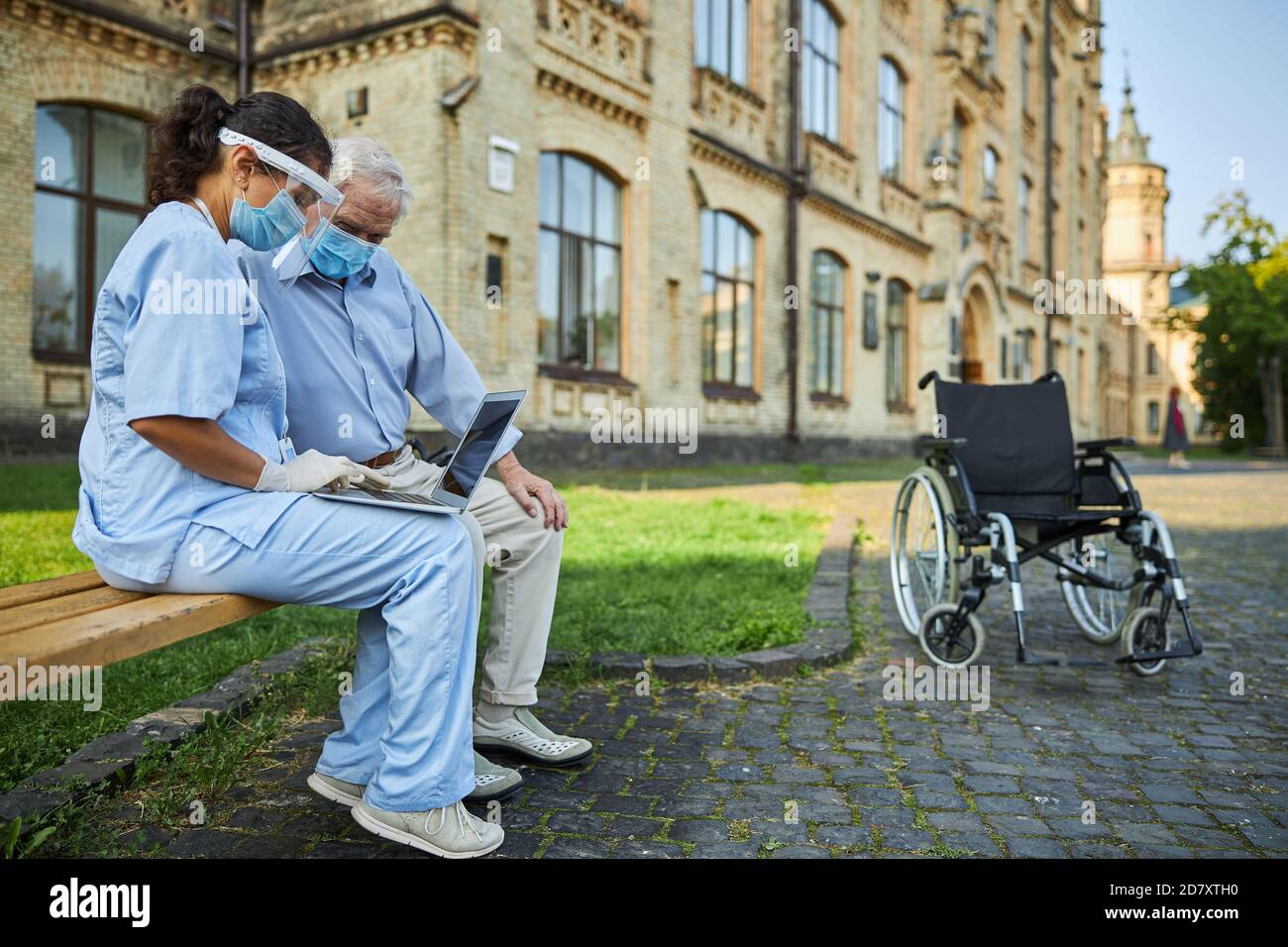 Junge Dame hilft dem älteren Mann mit dem Laptop Stockfoto