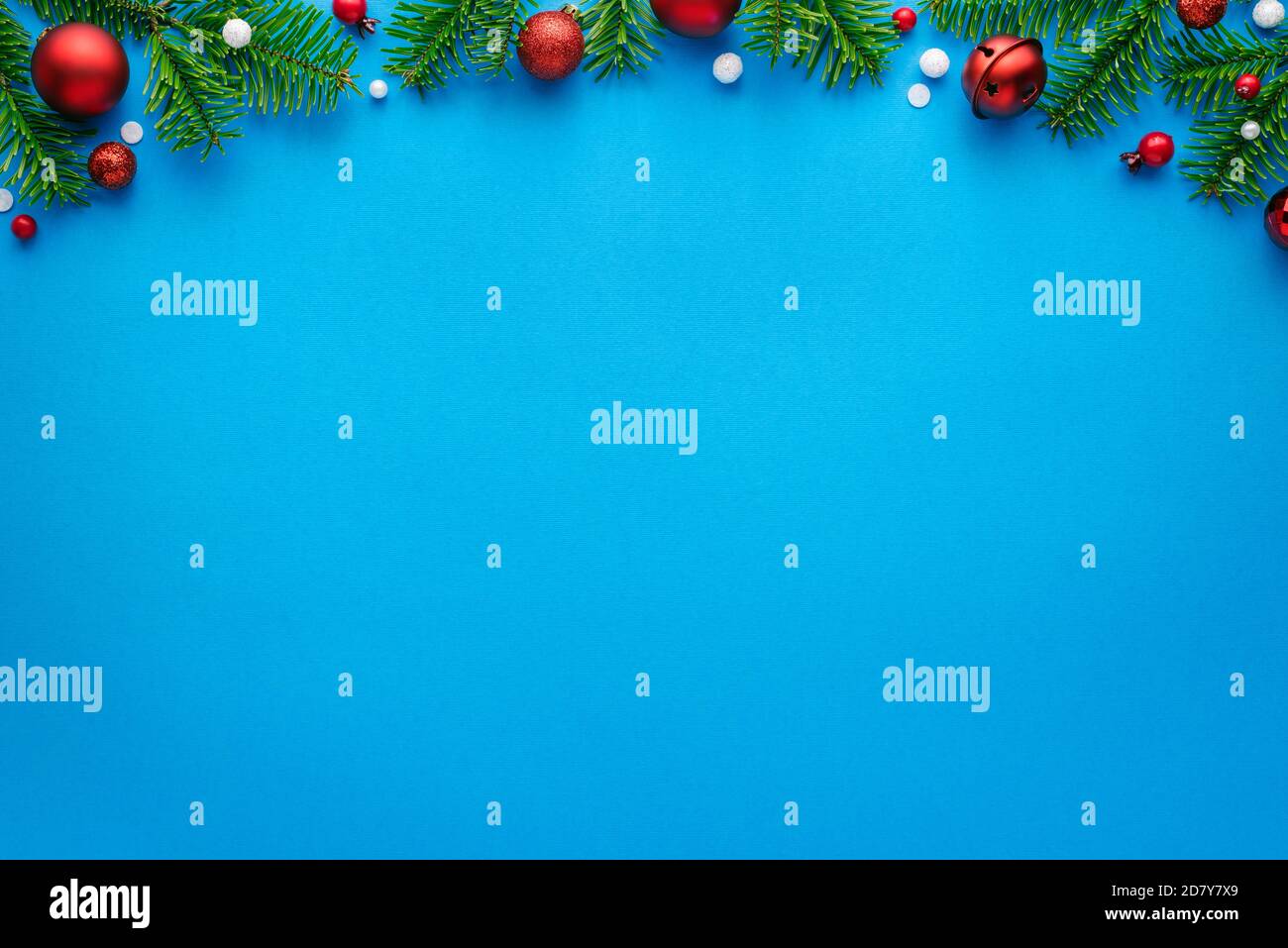 Weihnachtskarte mit Tannenschmuck auf blauem Hintergrund. Draufsicht mit Platz für festliche Texte Stockfoto