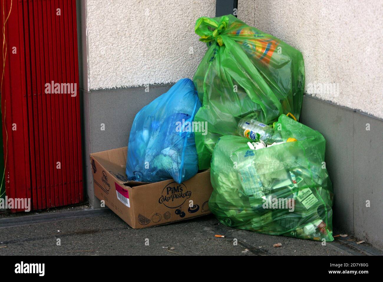 Plastiktüten, die hinter der Tür mit Haushaltsabfall gefüllt sind Stockfoto