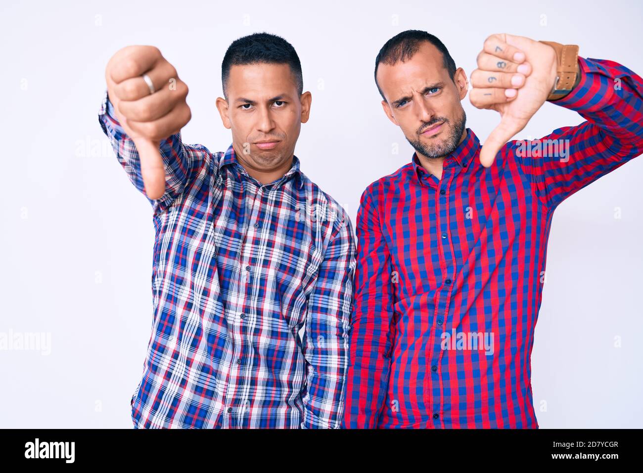 Junge Homosexuell Paar von zwei Männern tragen lässige Kleidung suchen unglücklich und wütend Ablehnung und negativ mit Daumen nach unten Geste. Schlechter Ausdruck. Stockfoto