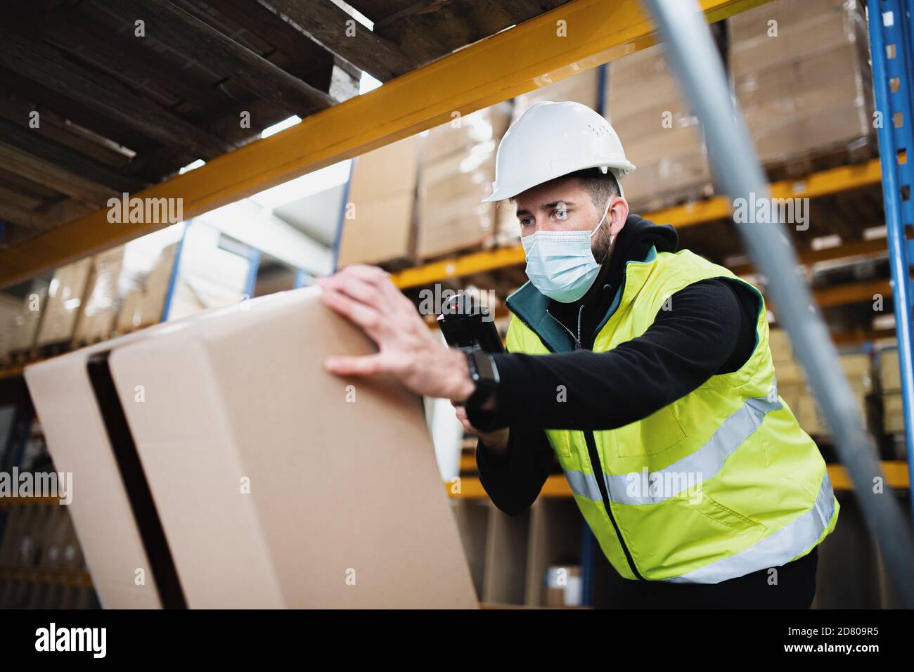 Mann Arbeiter arbeiten drinnen im Lager, coronavirus Konzept. Stockfoto