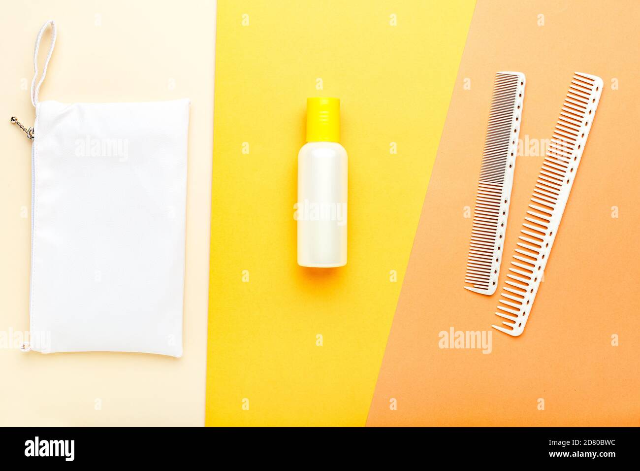 Shampoo orange Flasche mit Kämmen und Kosmetiktasche. Schönheitsbehandlungen, Kosmetik für die Haarbehandlung. Friseur Werkzeuge Haar Kosmetik Toilettenartikel. Oben Stockfoto