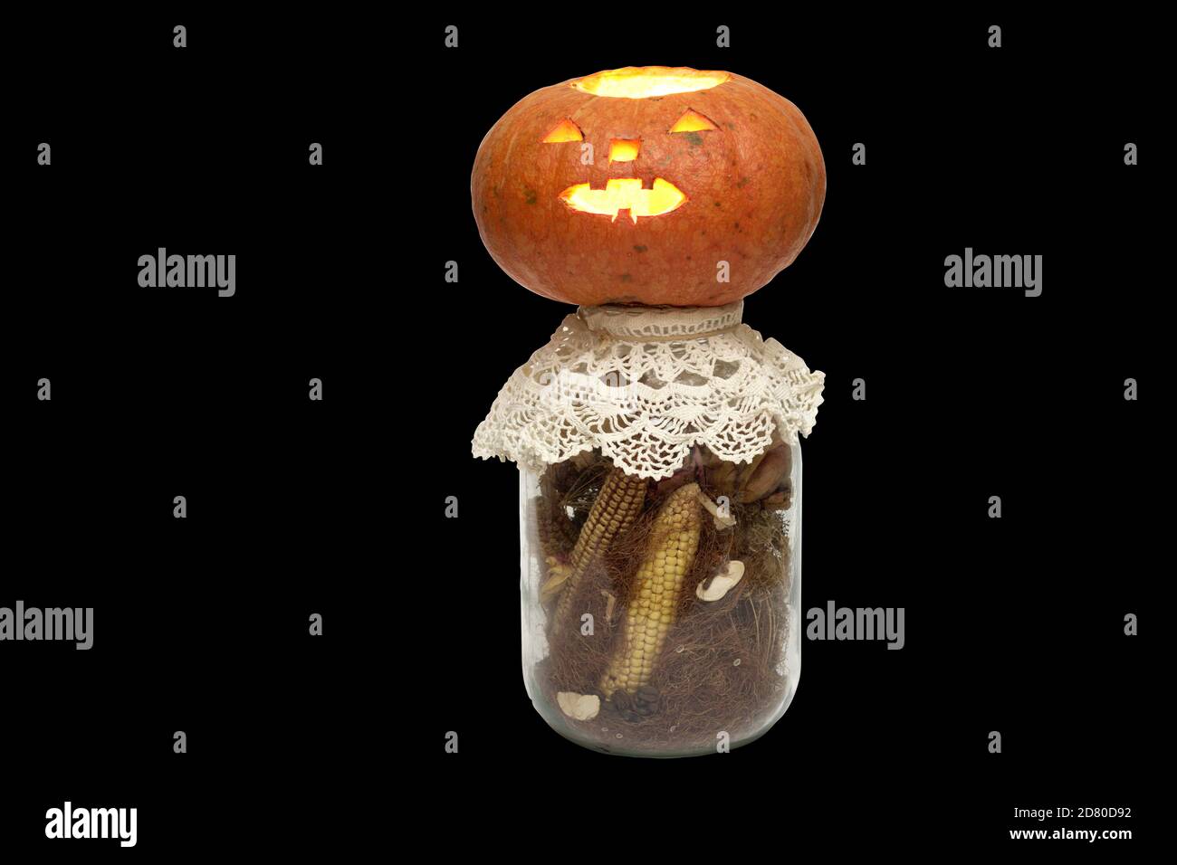 halloween Kürbis mit Kerze Laterne auf einer Flasche voller getrockneter Mais und Mais Stigmas. Isoliert auf schwarzem Hintergrund Stockfoto