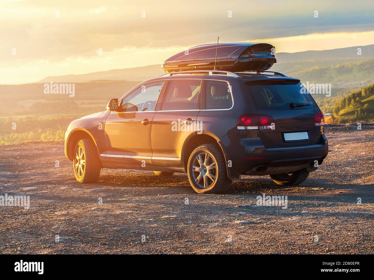 Fahrt im SUV in hügeligem Gelände bei Sonnenuntergang Stockfoto