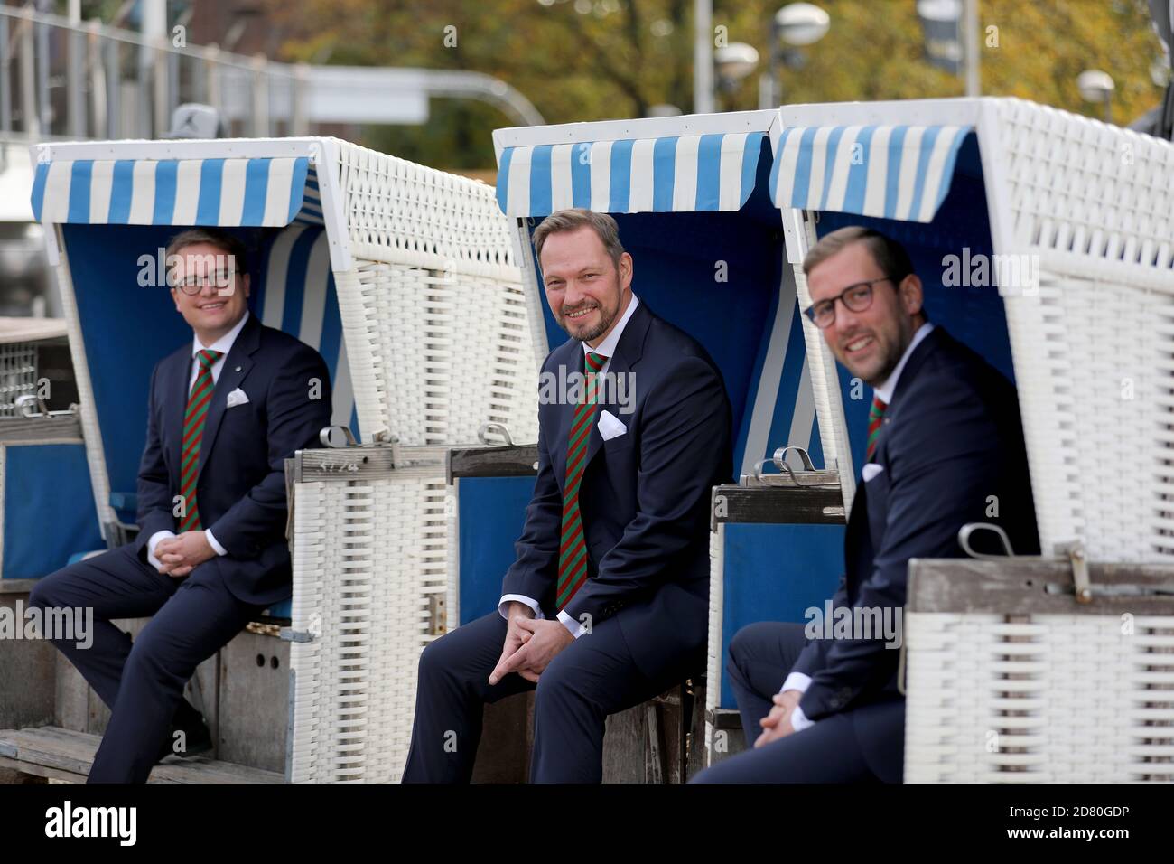 Köln, Deutschland. Oktober 2020. Das neue Kölner Triumvirat, bestehend aus Sven Oleff (M) als Prinz Sven I., Gereon Glasemacher (r), dem Bauern, und Björn Braun, der Jungfrau, sitzt in Strandkörben. Aufgrund der anhaltenden Pandemie hat das Festivalkomitee beschlossen, das Triumvirat zwei Jahre lang regieren zu lassen. Quelle: Oliver Berg/dpa/Alamy Live News Stockfoto