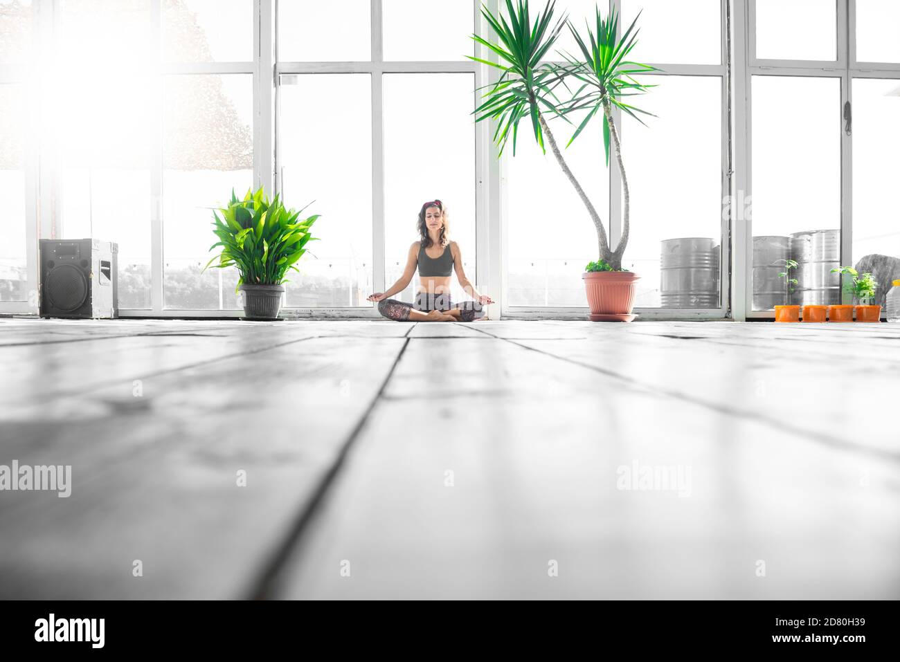 Frau in Lotusposition auf Indoor SUP Board während ihres morgendlichen Yogakursen. Stockfoto