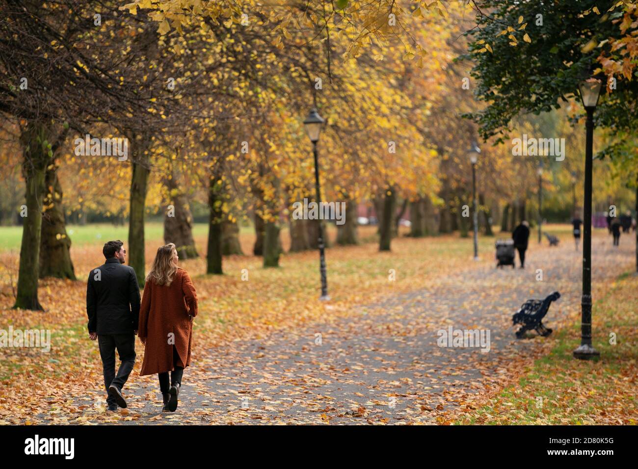 Liverpool, Großbritannien. Oktober 2020. Spaziergänger werden unter Herbstblättern im Sefton Park in Liverpool, Großbritannien, gesehen. Kredit: Jon Super/Alamy Live Nachrichten. Stockfoto