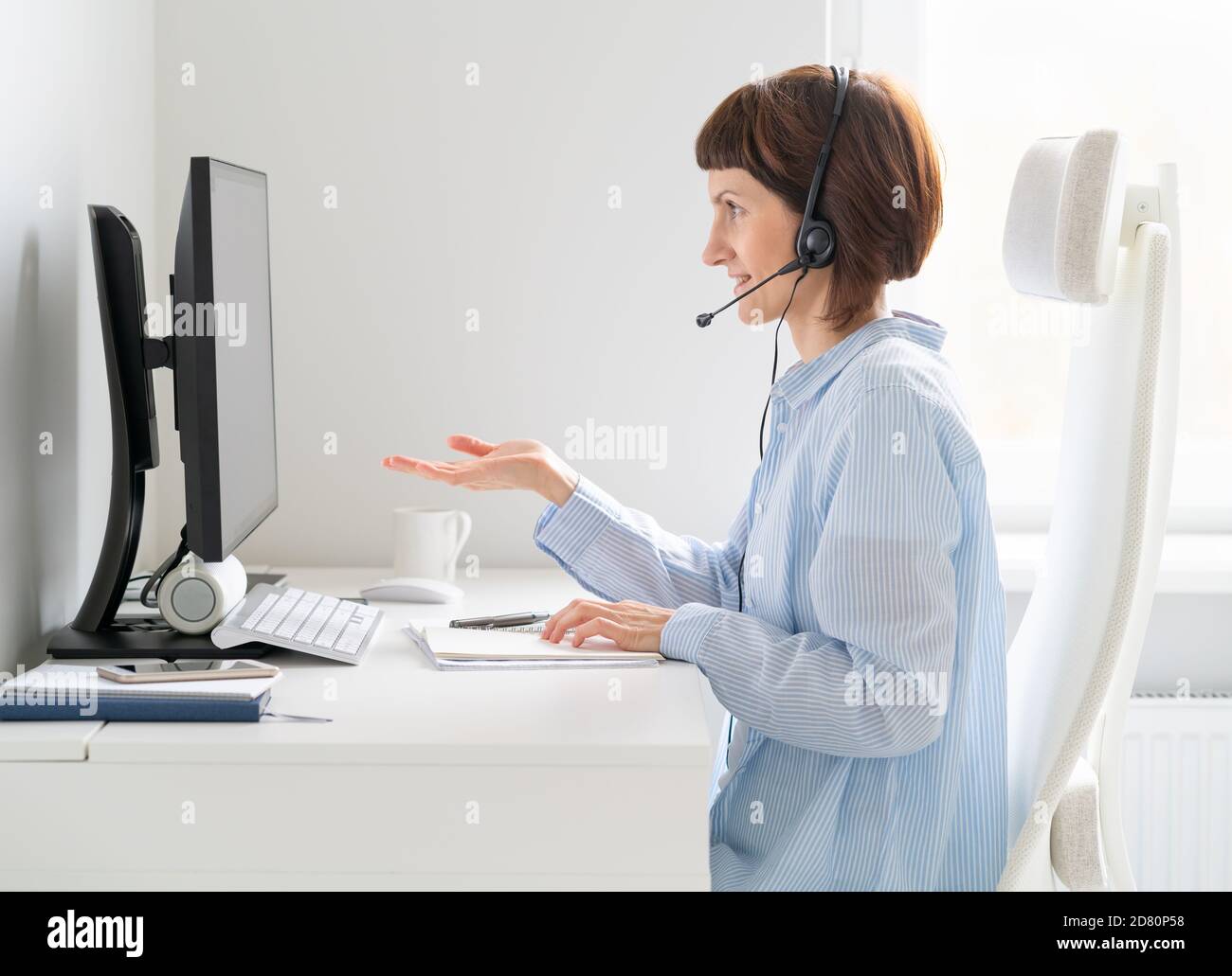 Reife lächelnde Frau im Gespräch bei Videokonferenz, Online-Präsentation, Workshop. Stockfoto