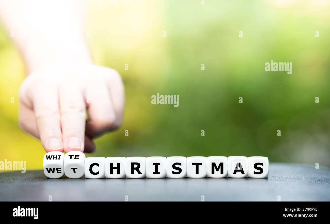 Weiße oder nasse weihnachten? Hand dreht Würfel und ändert den Ausdruck "Wet christmas" zu "White christmas". Stockfoto