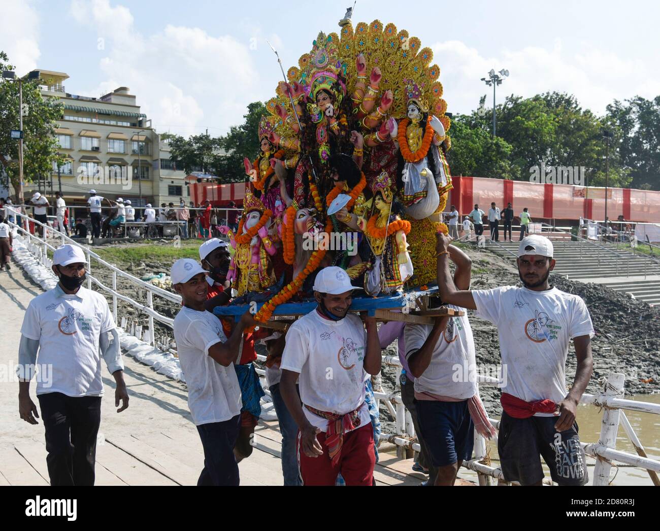 Städtische Arbeiter tragen ein Idol der Hindu-Göttin Durga für das Eintauchen in die Wasser des Brahmaputra Flusses während des letzten Tages des Durga Puja Festivals in Guwahati, Indien am 26. Oktober 2020. Der letzte Tag des Festivals heißt Vijay Dashmi, Vijaya bedeutet "Sieg" und Dashmi bedeutet "Zehntel". Durga Puja wird in den indischen Bundesstaaten Westbengalen, Assam, Jharkhand, Orissa und Tripura weithin gefeiert und gipfelt im Eintauchen der Idole der Hindu-Göttin Durga, die Macht und den Triumph des Guten über das Böse in der hinduistischen Mythologie symbolisiert. Kredit: David Talukdar/Alamy Live Nachrichten Stockfoto