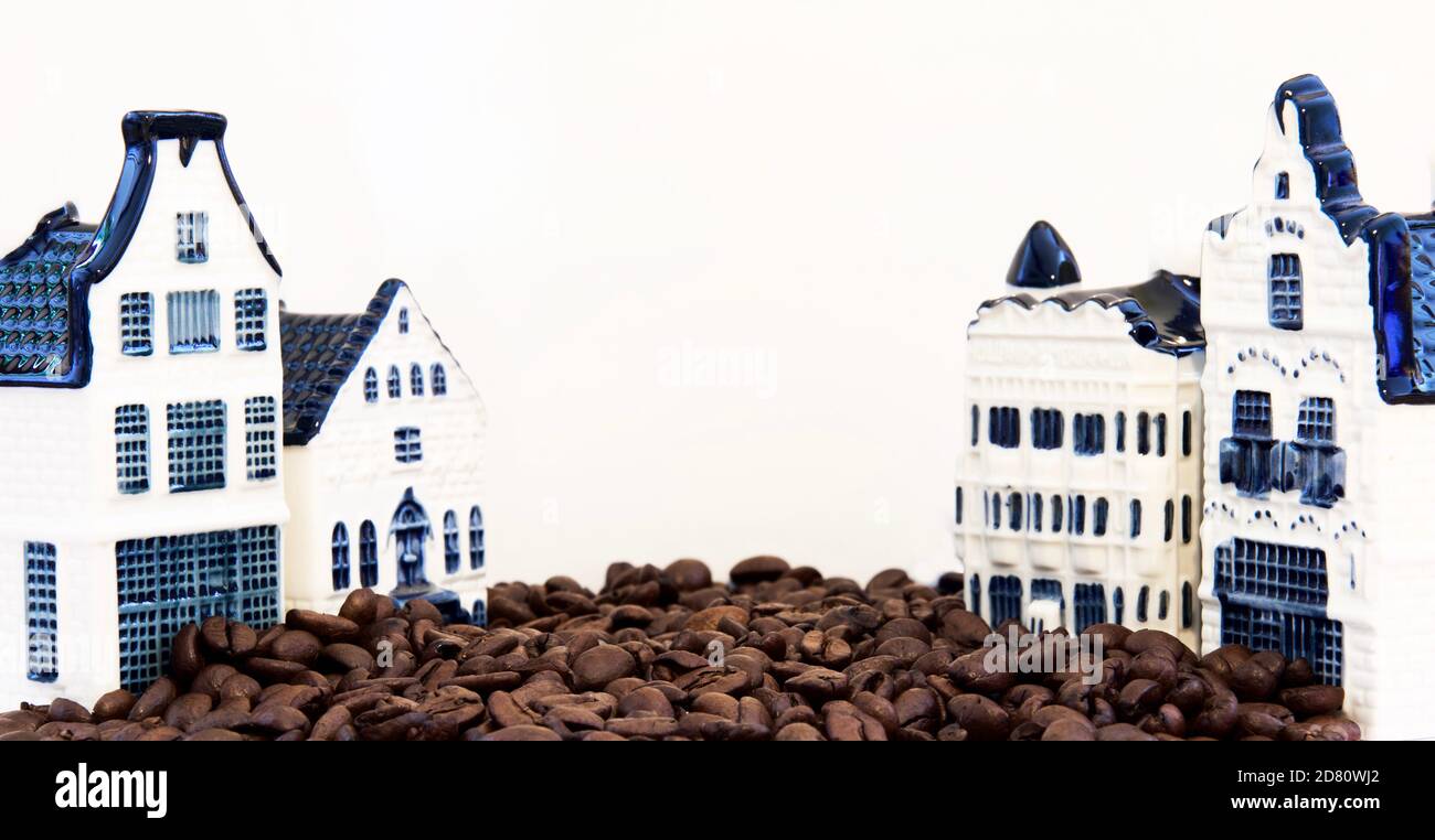 Rohe Kaffeebohnen auf der Straße, Szene mit Häusern, Café. Kreatives Konzept, Hintergrund, weißer Hintergrund, Kopierraum, horizontale Komposition. Stockfoto