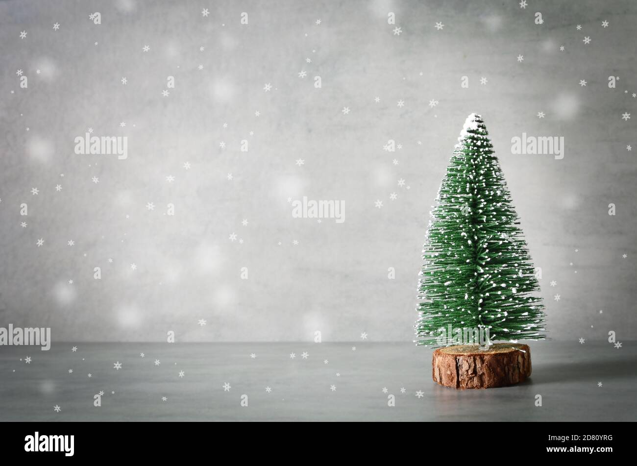 Minimalistische weihnachtskomposition mit dekorativer Tannenbaum, Holzschlitten, Schnee auf grauem Hintergrund. Urlaubskonzept. Stockfoto Minimalistische weihnachtskomposition mit dekorativer Tannenbaum, Holzschlitten, Schnee auf grauem Hintergrund. Urlaubskonzept. Stockfoto