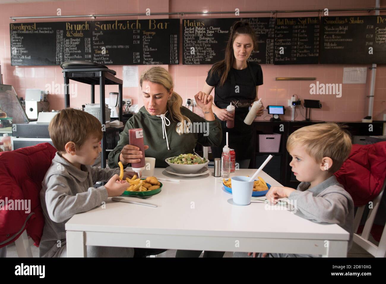 NEUÜBERMITTLUNG VON NAMEN LEIGH Anderson, mit ihren Söhnen Charlie Brown (links) und Albie Brown, essen eine Mahlzeit im Kitchen Cafe in Bermondsey, London, bieten kostenlose Schulmahlzeiten für Kinder über die Halbjahresferien. Gemeinden und Unternehmen versprechen weiterhin kostenlose Nahrung für Kinder in Not während der Halbzeitpause dieser Woche, nachdem die Regierung einen Labour-Antrag zur Verlängerung der kostenlosen Schulmahlzeiten in England über die Feiertage besiegt hat. Stockfoto