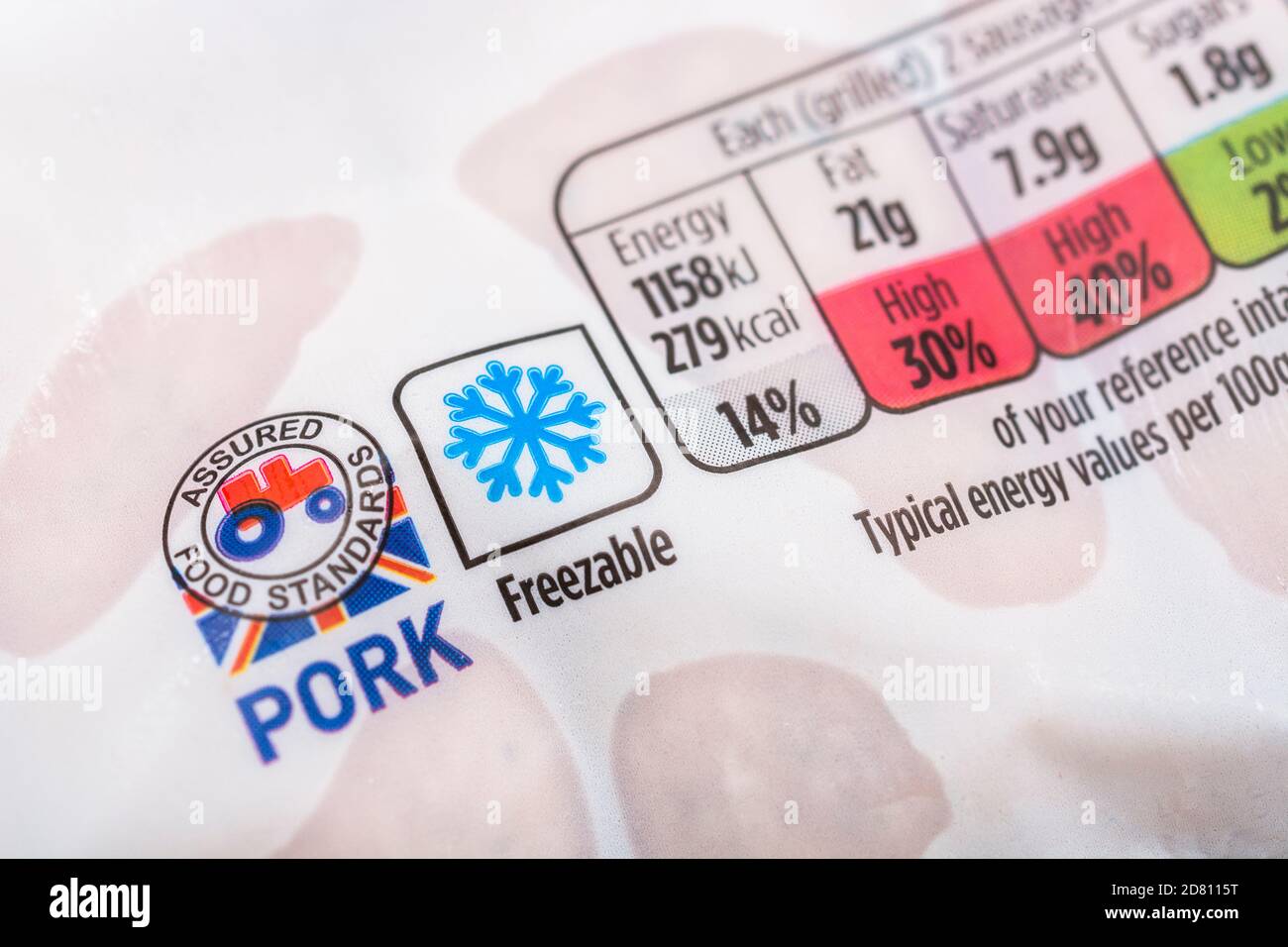 Mit Kunststofffolie umwickelte Schweinswürste von Asda mit dem „Food Assured Standard“-Logo des roten Traktors und der Grafik des Gefrierschranks auf der Verpackung + Ernährungsinformationen. Britische Agrarprodukte Stockfoto