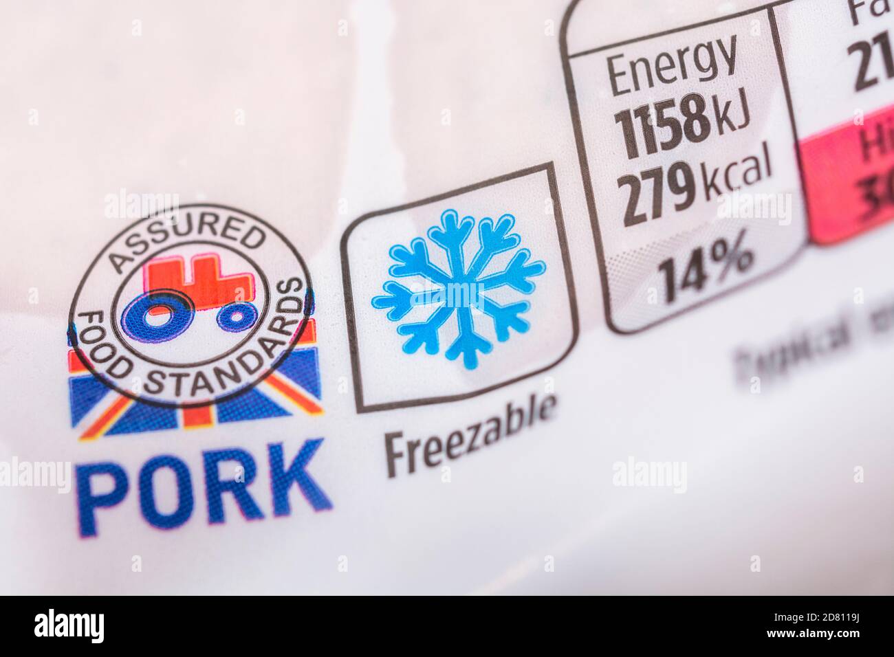 Mit Kunststofffolie umwickelte Schweinswürste von Asda mit dem „Food Assured Standard“-Logo des roten Traktors und der Grafik des Gefrierschranks auf der Verpackung + Ernährungsinformationen. Britische Agrarprodukte Stockfoto