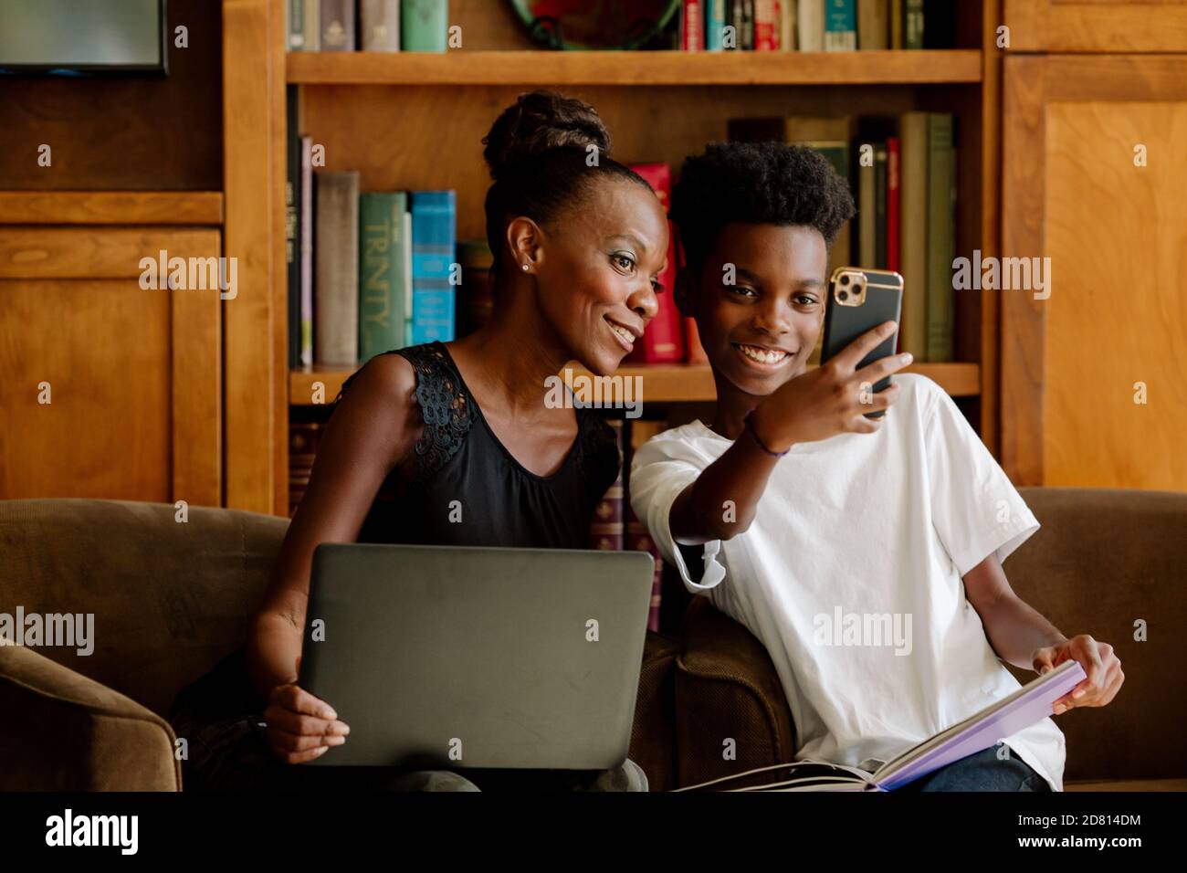 Afroamerikanische Mutter posiert für Selfie mit Sohn während der Heimschooling Stockfoto