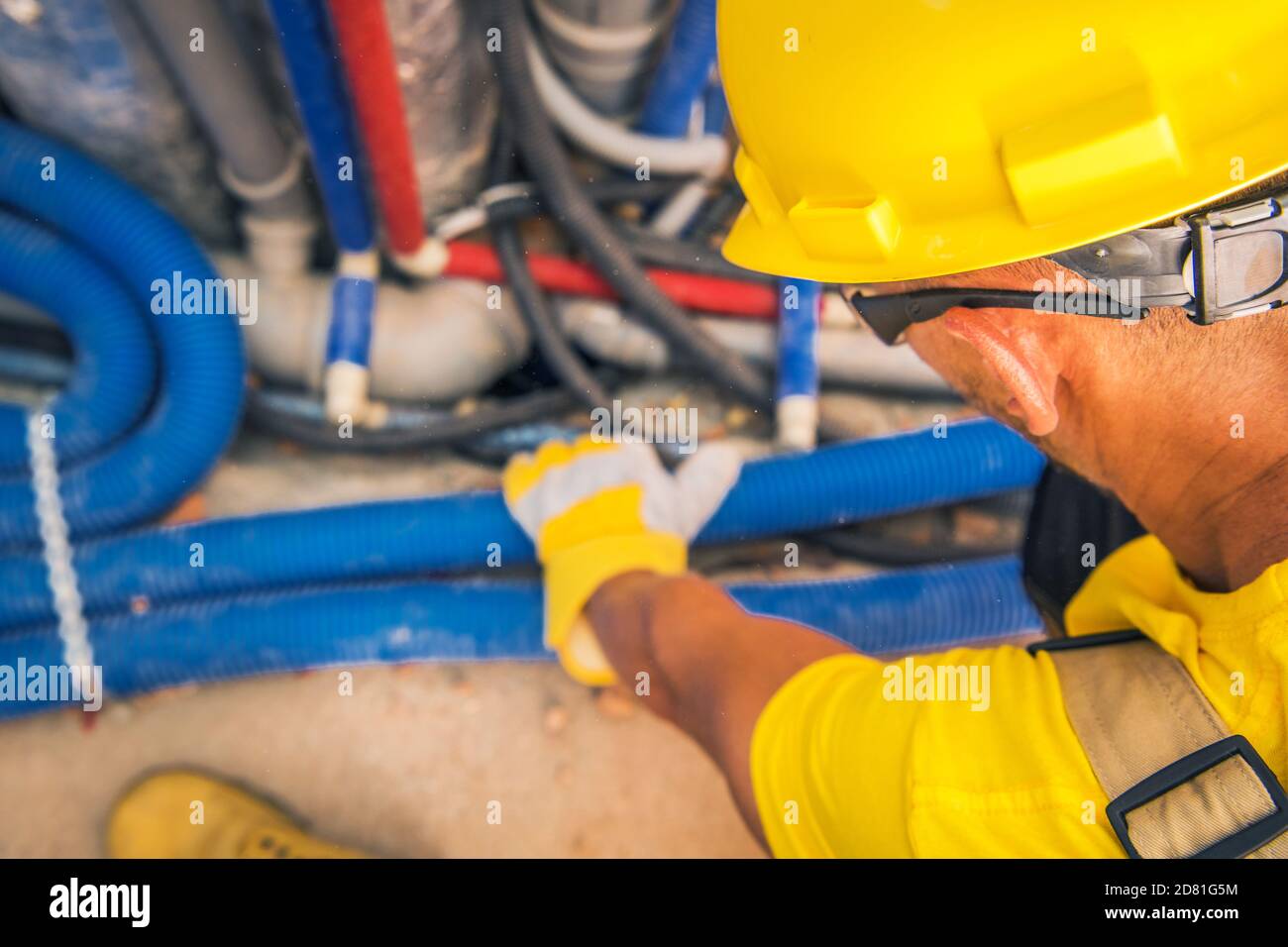 Hartmützenbereich Auftragnehmer mit Blick auf den Luftschacht, die Kanalisation und die elektrische Nabe und den abwärtsgerichteten Gebäudeschacht. Thema Baustelle. Stockfoto