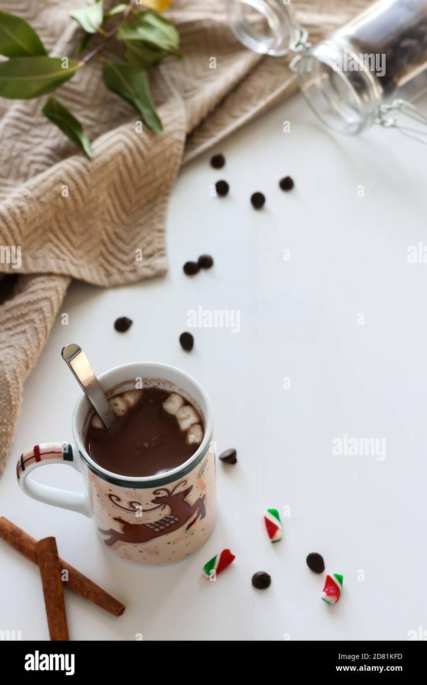 Weihnachtsbecher mit heißer Schokolade mit Zimtstangen, Schokoladenstückchen und Marshmallows Stockfoto