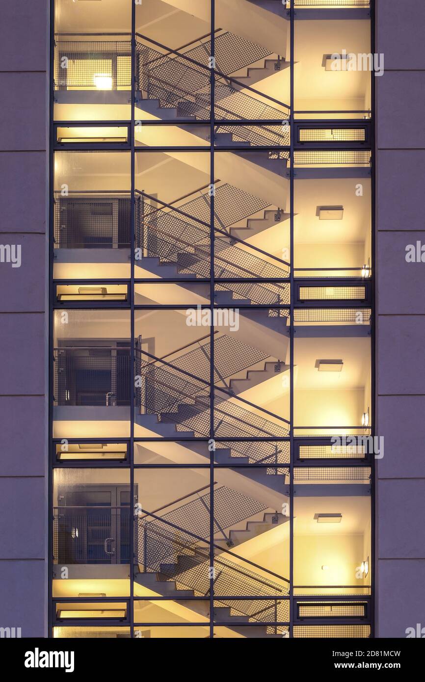 Leeres Treppenhaus mit Treppe beleuchtet im modernen Wohnblock angesehen Von außen durch Glaswand Stockfoto