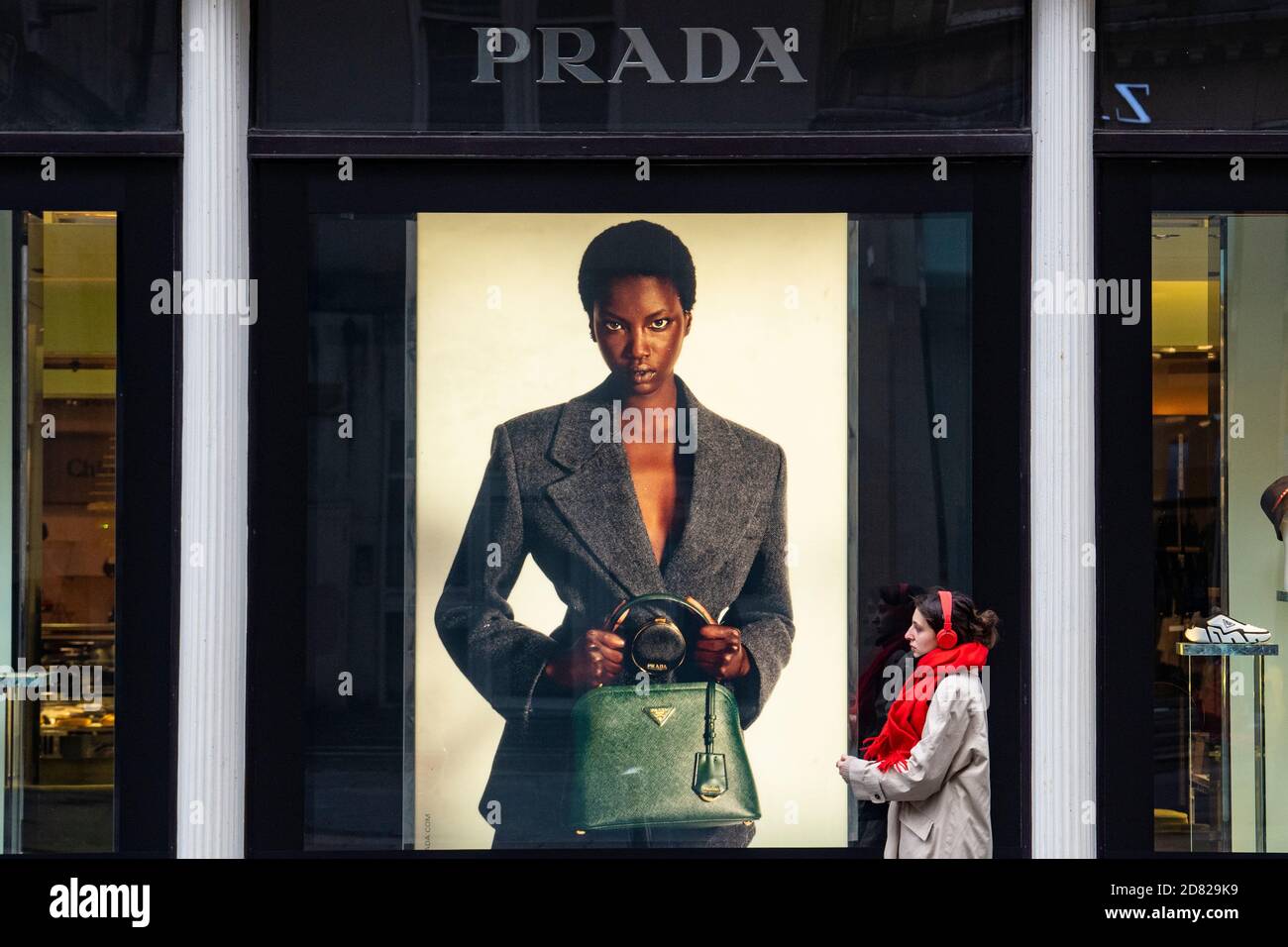Frau geht vorbei an Schaufenster für Prada im Fraser Kaufhaus, Glasgow, Schottland, Großbritannien Stockfoto