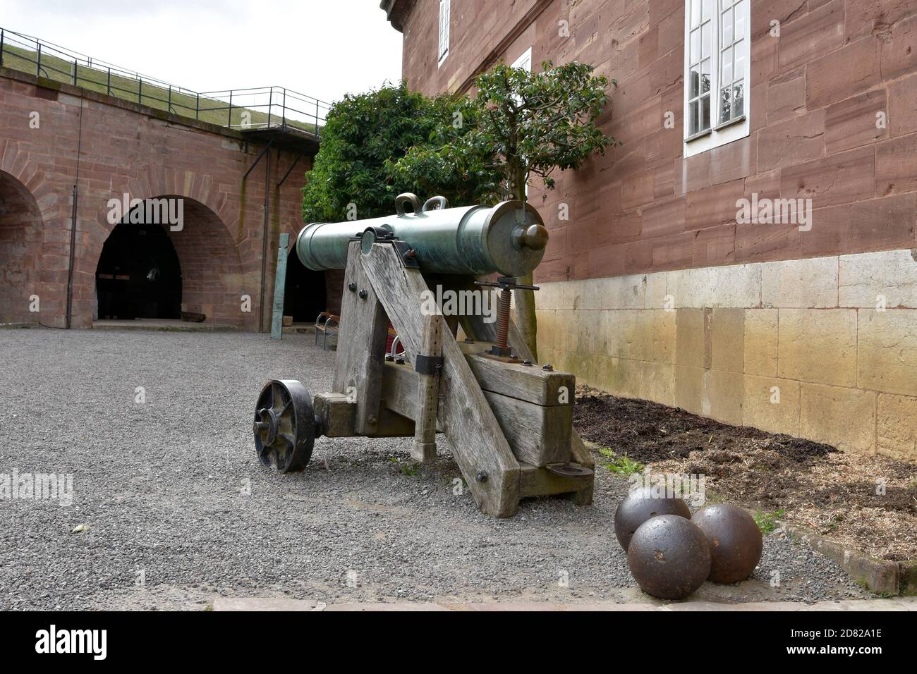 Kanone, eine historische Artillerie, Metall-Geschoss-Waffe mit drei Kugeln oder Geschosse auf dem Boden der Zitadelle oder Fort Belfort in Frankreich. Stockfoto