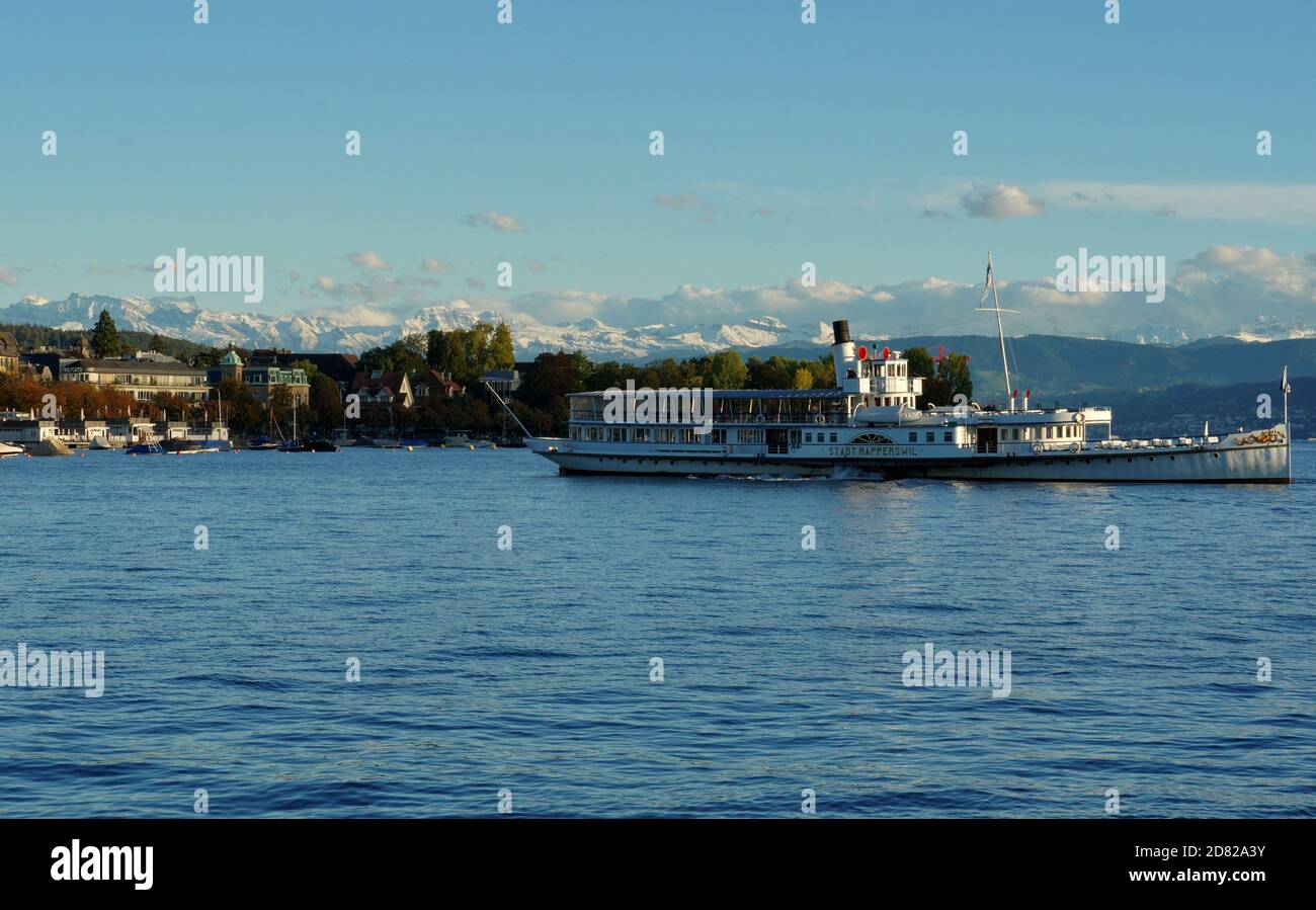 Ein Touristenschiff auf dem Zürichsee an einem sonnigen Sonntagnachmittag im Herbst. Am Horizont sind die Gipfel der Schweizer Alpen mit Neuschnee bedeckt. Stockfoto