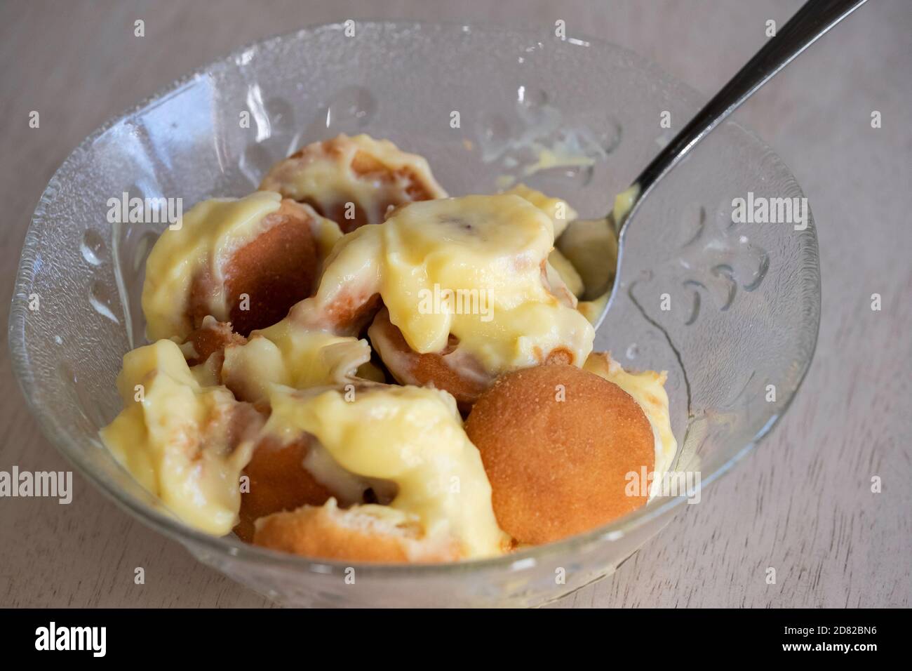 Nahaufnahme einer Portion Bananenpudding mit Pudding, Vanilleplätzchen und in Scheiben geschnittenen Bananen in einer Schüssel mit Löffel serviert. USA. Stockfoto