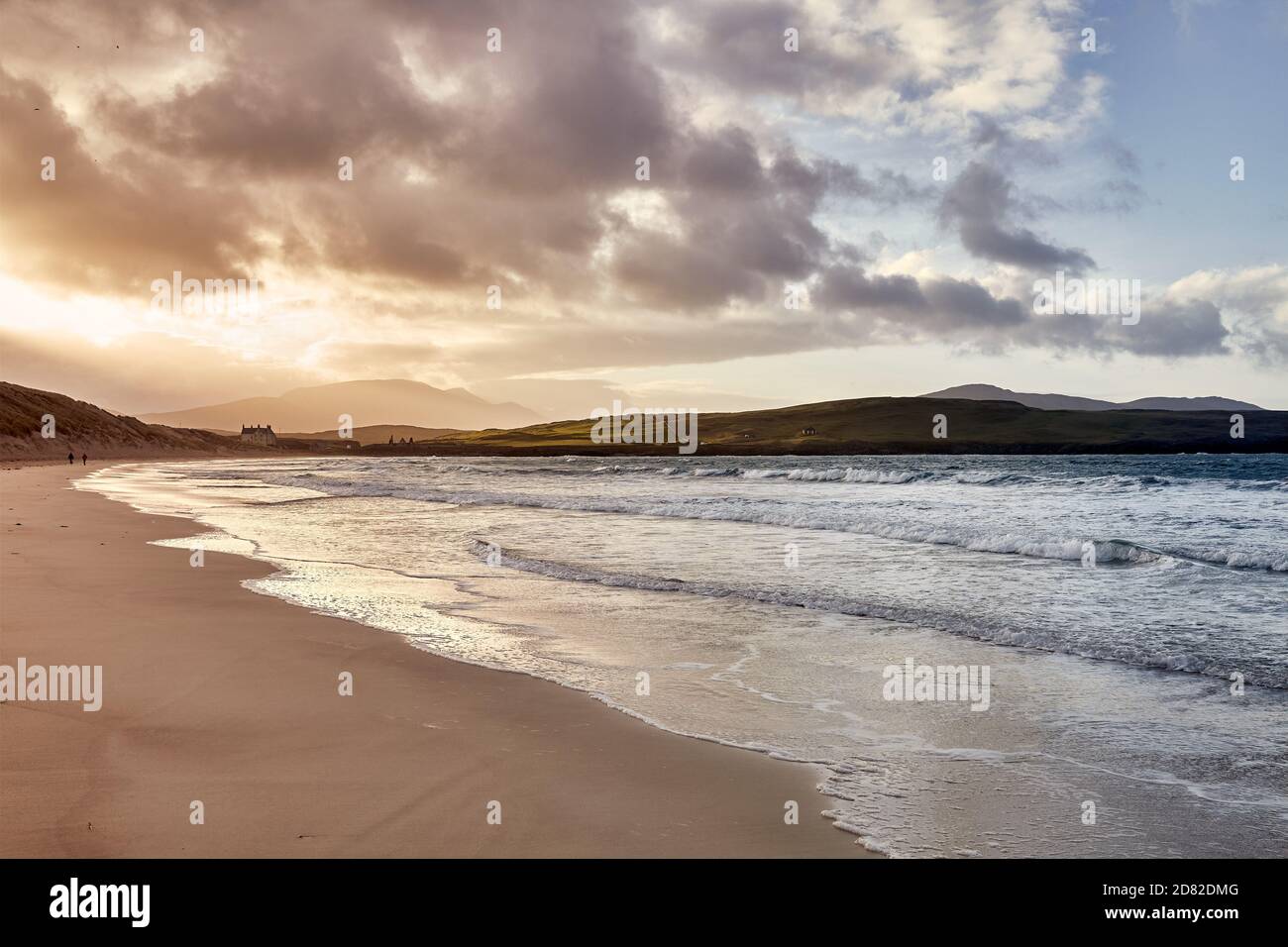 Ein entferntes Paar genießt einen Spaziergang an einem Winterstrand Stockfoto
