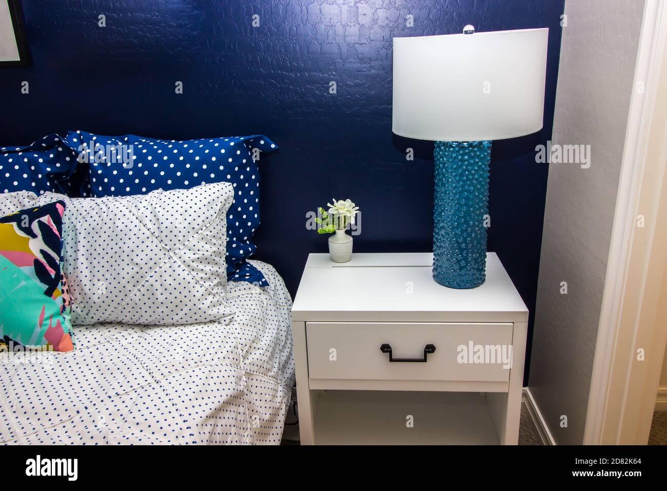Schlafzimmer Mit Blauer Akzentwand, Bett, Nachttisch Und Dekorationslampe  Stockfotografie - Alamy
