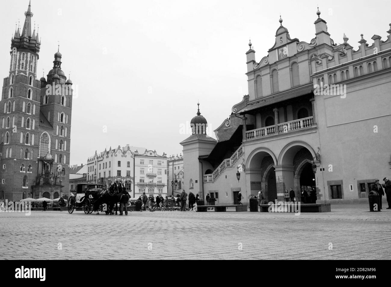 Ein fiacre geht an der Marienbasilika vorbei und nähert sich der historischen Tuchhalle auf dem mittelalterlichen Platz aus dem 13. Jahrhundert in Krakau, Polen. Stockfoto