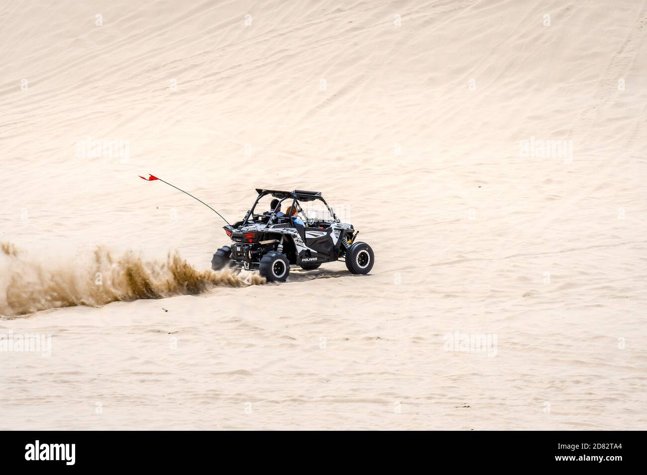 Geländewagen, der am späten Nachmittag die Oregon Sand Dunes fährt, Oregon-USA Stockfoto