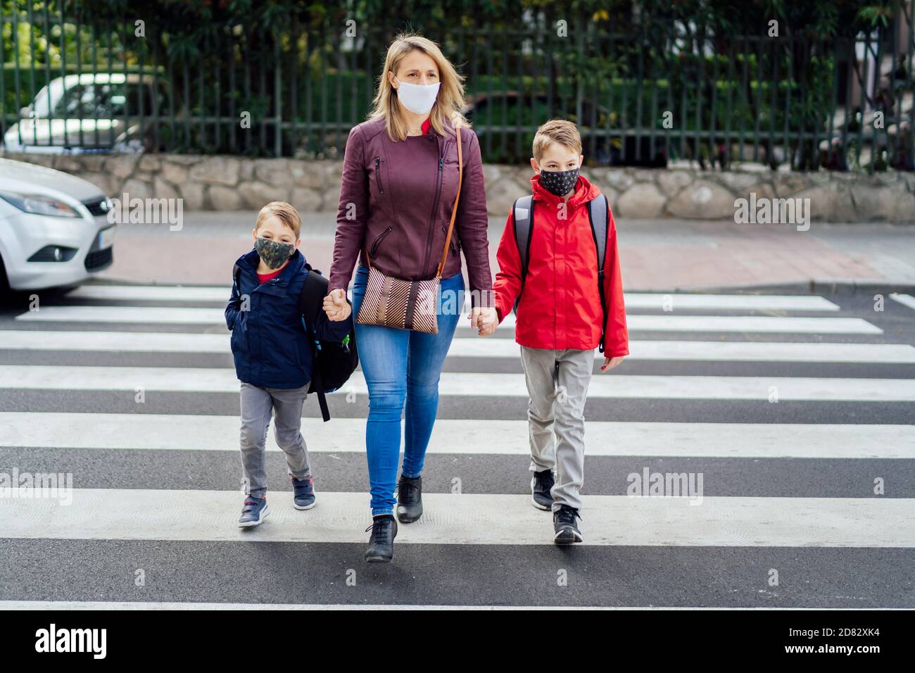 Mutter überquert die Straße mit ihrem Sohn Stockfoto