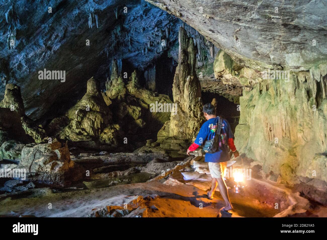 Führung durch eine Höhle mit Laterne Stockfoto