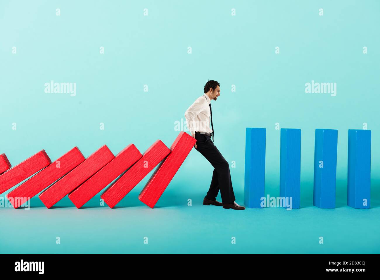 Konzept der covid19 Coronavirus Pandemie mit Geschäftsmann, der will Block fallenden Kette wie ein Dominospiel Stockfoto