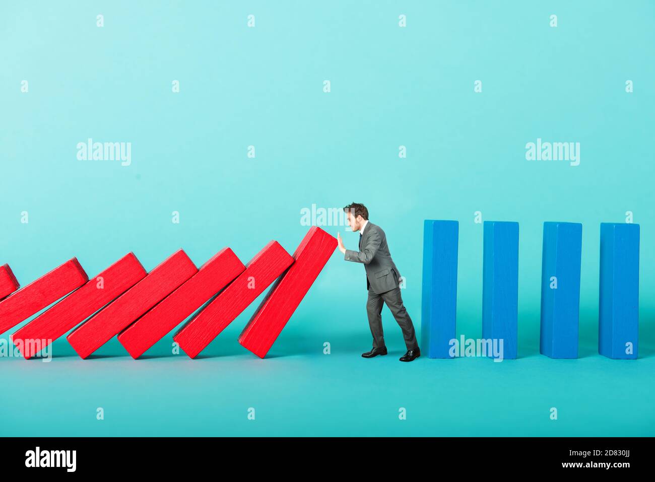 Konzept der covid19 Coronavirus Pandemie mit Geschäftsmann, der will Block fallenden Kette wie ein Dominospiel Stockfoto