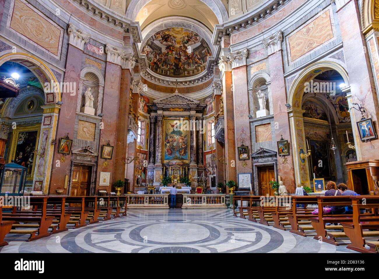 Gotteshäuser, Menschen in der Kirche, Inneres von San Giacomo in der Augusta-Kirche, Deckenfresken des Gotteshauses, Gewölbe und Altaraufsatz, Rom, Italien. Stockfoto