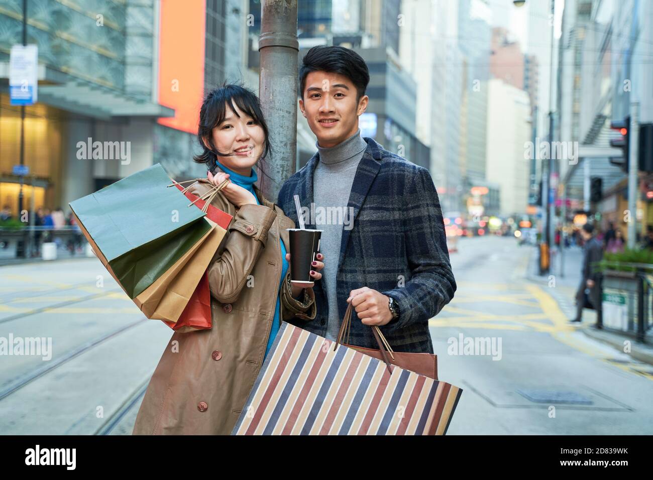 Außenportrait eines jungen asiatischen Paares mit Einkaufstaschen In der Hand Stockfoto